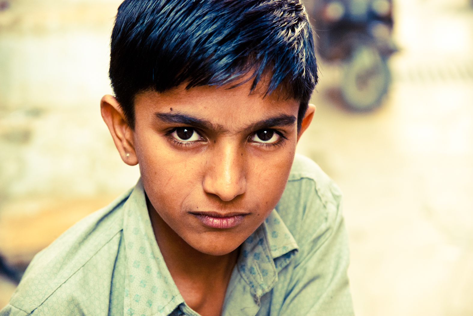 A child in a green shirt looking at the camera