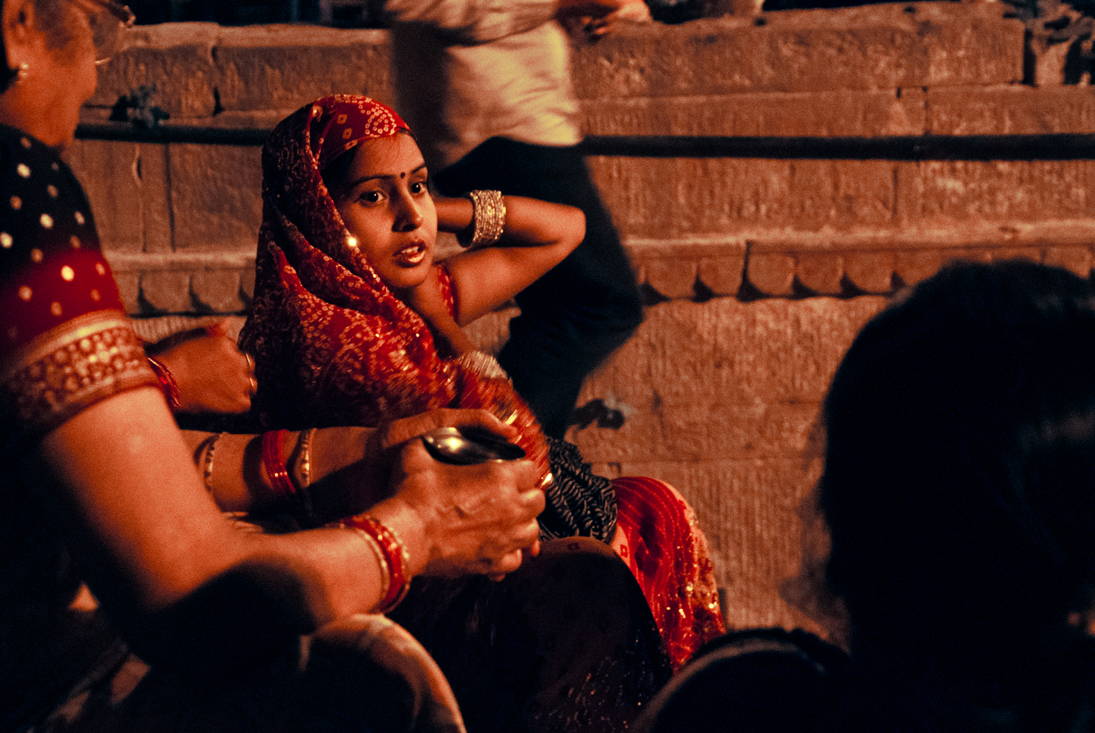 A figure in red seated on steps